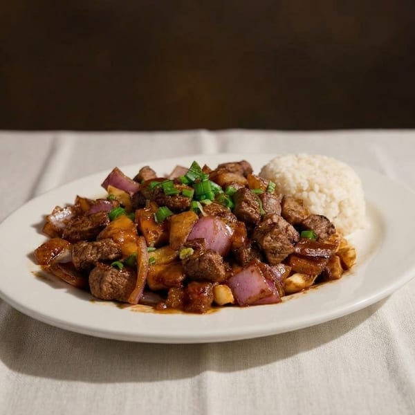 Peruvian Lomo Saltado with beef, red onions, and potatoes, served with white rice.